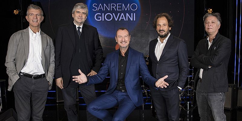 Foto der Musikkommission vor dem Logo von Sanremo Giovani, von links: Claudio Fasulo, Gianmarco Mazzi, Amadeus (sitzend), Leonardo De Amicis und Massimo Martelli.