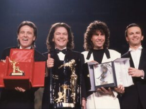 Pooh (Roby Facchinetti, Red Canzian, Stefano D'Orazio und Dodi Battaglia) präsentieren die beim Sanremo-Festival erhaltenen Preise. Die Bandmitglieder tragen Anzüge.