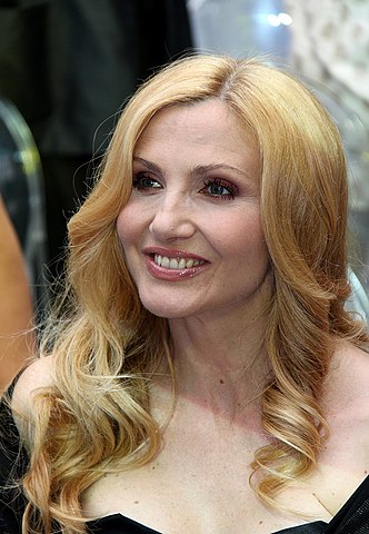 Lorella Cuccarini mit langen blonden Haaren und weit ausgeschnittenem schwarzen Kleid