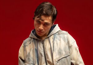 Settembre trägt eine helle Jeansjacke und blickt mit geneigtem Kopf in die Kamera