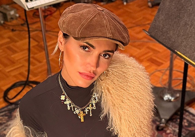 Serena Brancale mit vor dem Hintergrund eines Probenraums oder Studios. Sie trägt ein dunkles Oberteil und blickt ruhig in die Kamera.